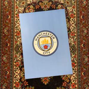 Snygg affisch med Manchester Citys logga på en ljusblå bakgrund. Perfekt för fotbollsfans som vill visa sitt stöd för laget. Affischen har en stilren design med klubbens emblem i mitten.  köp 1 för 80 kr eller 2 för 100 kr. 50x70m