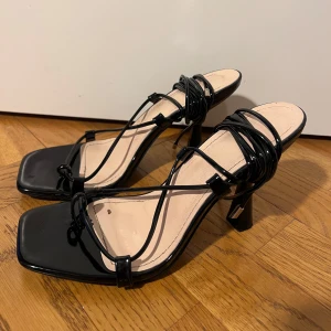 Svarta klackskor med snören  - Snygga svarta sandaler med klack och elegant snörning. De har en fyrkantig tå, finns mycket små tecken på användning men annars i bra skick🤍