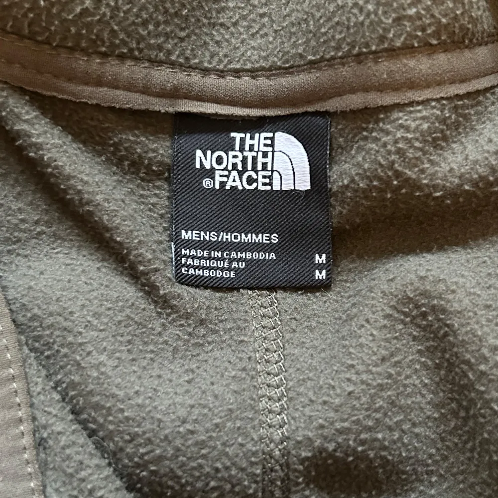 Säljer en grön fleeceväst från The North Face i mycket bra skick. Västen har en dragkedja framtill och två praktiska fickor med dragkedjor. Perfekt för höst och vår när du vill hålla dig varm utan att bli för varm. Passar både för träning och vardagsbruk.. Övrigt.