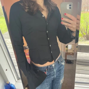 Svart skjorta från Anne Fontaine - Snygg svart skjorta från Anne Fontaine med en figurnära passform. Den har långa ärmar och knappar framtill. Perfekt för både vardag och fest! 🖤