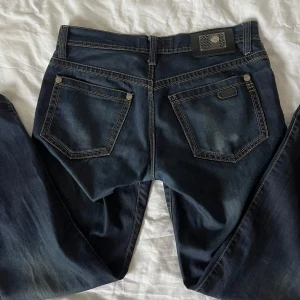 Mörkblå jeans  - Säljer dessa snygga mörkblå jeans köpta second hand i storlek W36 och L34. De är low waist och raka i benen, passar perfekt både till vardag och finare tillfällen. saknar dock en metall detalj på höger bakficka, men inget som märks! 