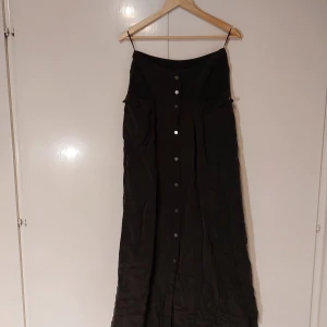 Mörkgrå lång kjol - Lång mörkgrå kjol med dropwaist. Väldigt djupa fickor. Skulle må bra av att ett strykjärn.