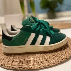 Gröna Adidas Campus sneakers - Hej! Säljer nu mina Snygga gröna Adidas Campus sneakers med vita ränder och gröna snören. Skorna har en klassisk design med en bekväm sula och hela inuti, om fler bilder önskas bara att skriva!😍inköpta för 1199kr 