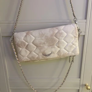 Beige quiltad axelväska från zadig  - Snygg beige axelväska med quiltat mönster och en elegant kedja som axelrem. Köpt i Paris från zadig. Säljer den för att väskan är oanvänd.