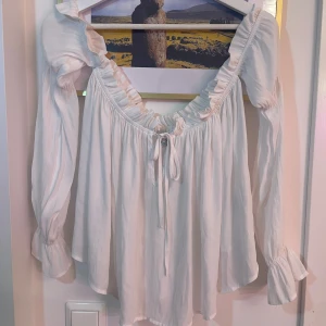 Vit offshoulder blus - Jätte fin vit offshoulder blus från Nelly i storlek S. Använd en gång och är i super bra skick!