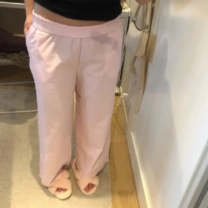Lågmidjade ljusrosa byxor - Supersöta byxor i strl M men passar mig som har S! De är i nyskick (använd en gång) och från bikbok. Jag viker ner de så de blir låga