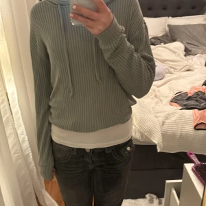 Jätte fin grön hoodie - Jätte fin grön hoodie som går och knyta i midjan och går även och knyta i luvan är randig och super fin använd ganska många gånger så jag säljer den för mindre pris fast även fast den är använd är den väldigt fin och ser ut som ny storlek xxs fast är typ xs 