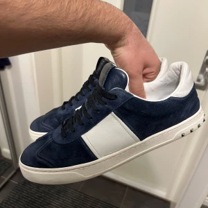 Valentino Flycrew - Valentino Flycrew i mörkblå färg. Sällan använda skor med en nit som saknas. Storlek 44. Skicket är riktigt bra, tecken på användning finns och avgör skicket gärna själva. Sjukt fina dojjor som inte producerats på flertalet år i en grym storlek, passa på att slå till!!! ENDAST SKOR!!