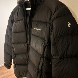 Svart dunjacka från Peak Performance - Säljer min svarta peakjacka då den är för liten för mig. Den har hål i vänstra armen, saknar därför vaddering där (se bild ovan) annars är den väldigt fin 🩷