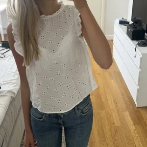 Vit blus från H&M - Söt vit blus från H&M med broderade blommor och volangdetaljer 🥰