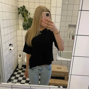 Svart kortärmad topp med knappar - Jag säljer en svart tre kvarts tröja med knappar på sidan💕 säljer så den inte kommer till användning! Tröjan är bara använd nån gång och är i mycket bra skick, pris kan diskuteras💗