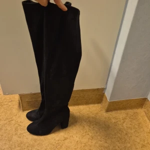 Svarta overknee stövlar från NLY Shoes - Snygga svarta overknee stövlar från NLY Shoes med dragkedja på insidan. Perfekta för en stilren look med klack för extra höjd.