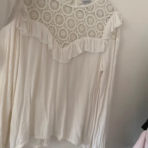 Vit långärmad blus  - Super fin blus som tyvärr inte kommer till användning! OBS tråden vid knappen vid nacken har gått av men har knutit fast den.