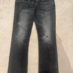 Svarta jeans med slitningar - Snygga svarta jeans från LTB med slitningar på framsidan. De har en klassisk femficksdesign och knappgylf. Perfekta för en avslappnad stil. W32, L32