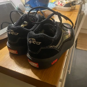 Svarta Vans skateboardskor - Säljer ett par svarta Vans skateboardskor med snörning och röda detaljer. Skorna har en robust sula med bra grepp och är designade för skateboarding. De har en PopCush-innersula för extra komfort. Helt nya använda 1-2 gånger 
