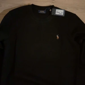Svart tröja från Polo Ralph Lauren - Snygg svart tröja från Polo Ralph Lauren med det klassiska broderade logotypen på bröstet. Nyskick 