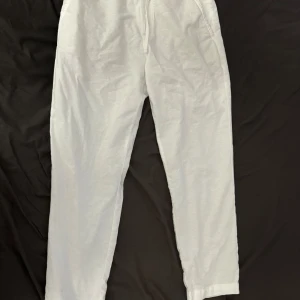 Zara linnebyxor strl M - Säljer ett linnebyxor från Zara vita  med elastisk midja och avslappnad passform. Perfekta för en bekväm och stilren look. Använd 2 gånger och säljs då de inte passar mig längre. Perfekt skick. Inga märken och inget slitage. 
