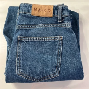 Blå jeans från NA-KD - Mörkblåa straight leg Jeans från NA-KD. Jeansen är i storlek 32. Knappt använda och är i väldigt bra skick