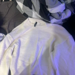 Vit stickad tröja från H&M - Säljer en stilren vit stickad tröja från H&M. Tröjan har en klassisk design med rund hals och långa ärmar. Perfekt för kyligare dagar och enkel att matcha med olika outfits. Väldigt basic men endå fin! 