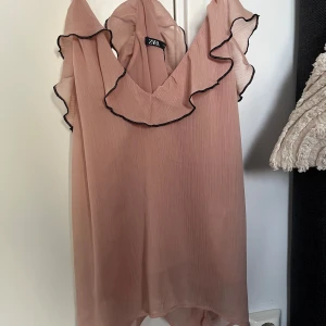 Rosa blus från Zara - Säljer en söt rosa blus från Zara med volangdetaljer och svarta kanter. Aldrig använd då jag inte haft tillfälle för den. Prislapp kvar och aldrig använd 
