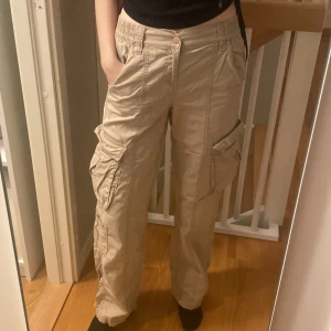 Beige cargobyxor  - Säljer ett par beige cargobyxor från H&M Divided. Sitter skönt med resårband i midjan. 100% bomull. Så gott som nya!