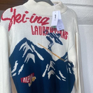 Vit stickad tröja perfekt til afterski  - Säljer en cool vit stickad tröja från Gina tricot med ett retro skidmotiv i blått och rött. Perfekt till skidsäsong och afterskin. Helt ny😊