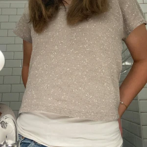 Beige stickad t-shirt  - Snygg beige topp med vitprickiga detaljer. Kortärmad design som passar perfekt för en avslappnad stil. Perfekt att bära över ett linne för en lager-på-lager-look. Använt skick , ingen storlek men skulle säga xs 🩷skriv privat för fler bilder 