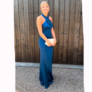 Blå långklänning med öppen rygg - Elegant blå långklänning i satin med halterneck och öppen rygg. Perfekt balklänning💙använt 1 gång på balen förra året, nypris 1700 kr
