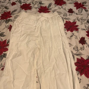 Vita linnebyxor - Säljer ett par bekväma vita linnebyxor med elastisk midja och dragsko. Lappen på byxorna har jag klippt bort. Byxorna har använts några gånger innan. Jag köpte byxorna för cirka 400kr så säljer dom lite billigare för att dom har använts. Skriv om ni vill ha flera bilder💓💓