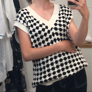 Knit vest - Stylish black and white knitted vest from MNG with a pattern. The vest has a v-neck design and ribbed edges and collar. 