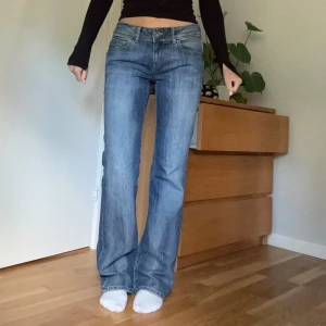 Lågmidjade jeans  - Ett par lågmidjade bootcutjeans från Tommy hilfiger i blå tvätt. Snygg modell och bra skick. Midjemått 39cm rakt över och innerbenslängd 84cm.
