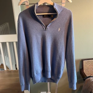 Ljusblå Ralph Lauren halfzip  - snygg halfzip som jag har köpt för 1700kr. storlek M, Använd ett fåtal gånger, i bra skick. Men den har en liten tråd som sticker ut, knappast syns när man har den på. kolla bild.