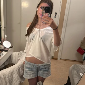 Vit blus med detaljer - Säljer denna blus med fina blomdetaljer. Unik och kan bäras på olika sätt! Skriv vid frågor💗