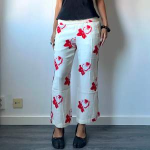 •Cream white straight leg crepe trousers with red flower print, from scandi brand Ganni. Small hole on front  • SIZE - S / EU 36 • BRAND -  Ganni • MATERIAL - 100% viscose