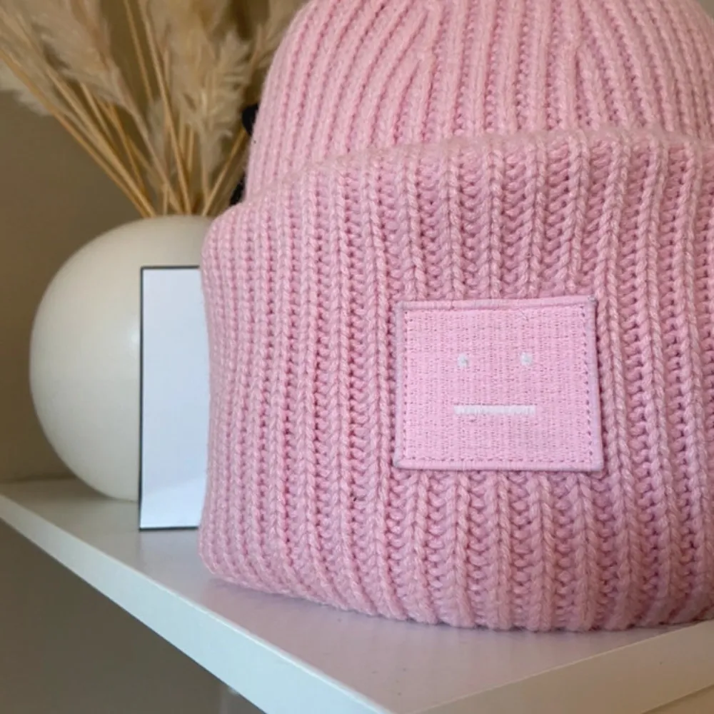 Säljer en superfin rosa stickad mössa från Acne Studios. Den har en ribbad design och ett ikoniskt ansiktsmärke framtill. Perfekt för att hålla sig varm och snygg under kyliga dagar. Passar till alla dina outfits!💖🩷💕. Accessoarer.