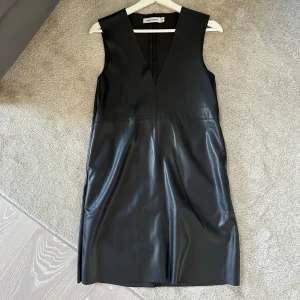 Skinnklänning (imitation)  - Skinnklänning från carin wester, använd cirka tre gånger. Bra skick. Snygg med plagg under (haft skjorta under). 