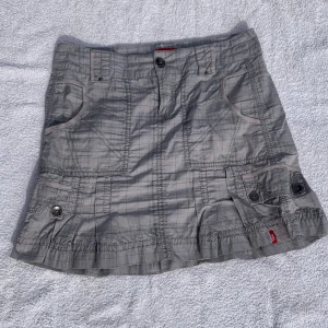Minikjol  - Så snygg ljusgrå rutig kjol från Edc med coola detaljer och fickor (!!!) både fram och bak. Storlek 34 men passar mig med typ M. Midjemått: 40 cm. Längd: 42 cm. Köpt second hand🩶