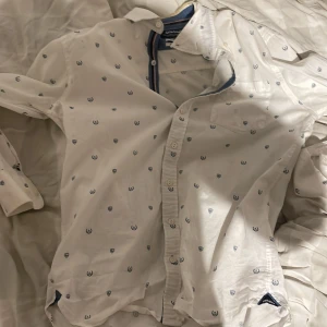 Sebago skjorta strl s men sitter som xs - Säljer denna skjorta då den är för liten den är i toppskick förutom en lite defekt där ja spillt kaffe du kan sa på bild 3 men absolut inget som syns när man har på har du några mer frågor ställ dem gärna!