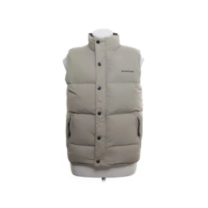Beige dunväst från Rockport - Säljer en snygg och varm beige dunväst från Rockport. Västen har en hög krage och stängs med både dragkedja och knappar. Perfekt för kyliga höst- och vinterdagar. Den har två praktiska fickor med dragkedja framtill. Färg gråbeige i mycket fint skick. 