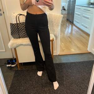 Säljer ett par snygga svarta kostymbyxor. De är high/midwaist och har en bootcut passform som ger en elegant look. Perfekta för både vardag och fest!