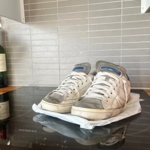 PHILIPP MODEL MED TEXT UNDER!! - Säljer ett par vita Philip Model!! MED TEXT UNDER! De är använda och har en klassisk design med snörning. Perfekta för en avslappnad eller grisch stil. Strl är 42 men funkar även för 41 eller 43. De är lite slitna pga att jag kört moppe med de 2 gå