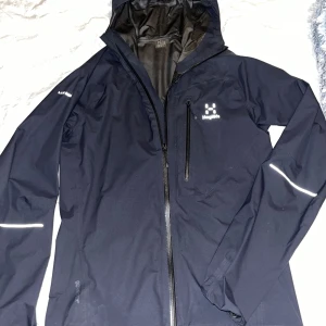 Haglöfs jacka  - Haglöfs jacka för herr i storlek xs kan passa S också Inte använd så mycket  Endast en liten skada vid sidan av dragkedjan som ni kan se på sista bilden men det går fortfarande att ha på sig den och dra upp dragkedjan. Sänker pris vid snabb affär 