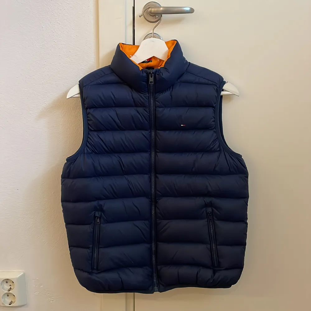 Mörkblå väst från Tommy Hilfiger, storlek 164. Använd ett fåtal gånger, mycket fint skick. Frakten är inkluderad.. Takit.