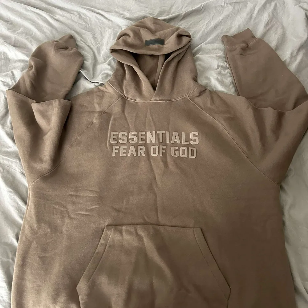 Säljer en Hoodie från Fear of God Essentials i frägen wood. Den är i storlek XL och oanvänd. Den är såklart äkta och digitalt kvitto finns. Hoodies.