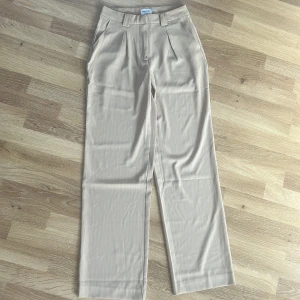 Kostymbyxor  - Använda en gång. Raka kostymbyxor, är ej genomskinliga. Från NA-KD. Superfint fall, lätt tyg. Kritstrecksrandiga. 