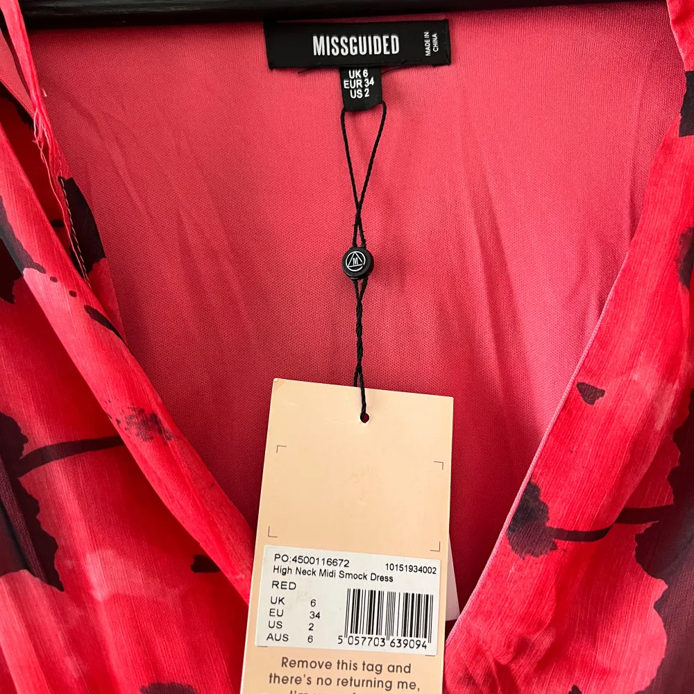 Säljer en superfin röd klänning från Missguided med ett blommigt mönster i svart och rött. Klänningen har långa ärmar och en v-ringad design med resor i midjan. Perfekt för festliga tillfällen! Prislapp kvar och aldrig använd. . Klänningar.