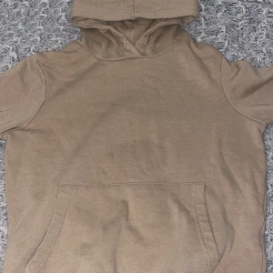 Beige hoodie från 157 - Säljer en beige hoodie från 157. Den har en klassisk design med en stor ficka framtill och en bekväm huva. Perfekt för en avslappnad stil.