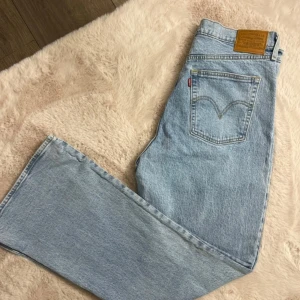 Levis Ribcage Flare Jeans - Snygga ljusblå Levis Ribcage Flare jeans med hög midja och utsvängda ben. Tillverkade i bomull med en liten del elastan för extra komfort. Perfekta för en trendig look. Alldrig använda! 
