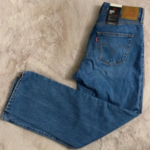 Levi's 501 Jeans i blå denim - Klassiska Levi's 501 jeans i blå denim. Dessa jeans har en rak passform och är tillverkade av högkvalitativt denim. Perfekta för en tidlös stil. Alldrig använda!