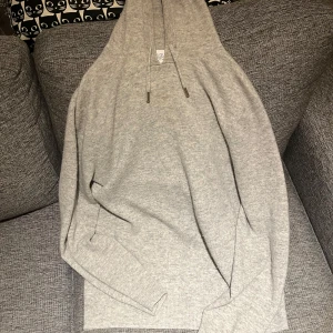 Grå hoodie från Ahlquist Clothing - Säljer en stilren grå hoodie från Ahlquist Clothing. Materialet är 100% merinoull vilket gör den väldigt bekväm oavsett årstid. På bilden är jag ungefär 180.